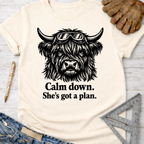 Women's funny woodworking graphic tee shirt for female woodworkers, makers, and DIY builders — Sawdust & Ponytails. Cream short-sleeve t-shirt with a black graphic of a Highland cow wearing goggles and text "Calm down. She's got a plan.