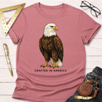 Dusty rose 100% cotton t-shirt with a detailed bald eagle graphic and "CRAFTED IN AMERICA" text.