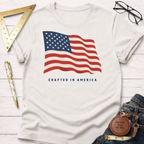 White short-sleeve t-shirt with a waving American flag and "CRAFTED IN AMERICA" text.
