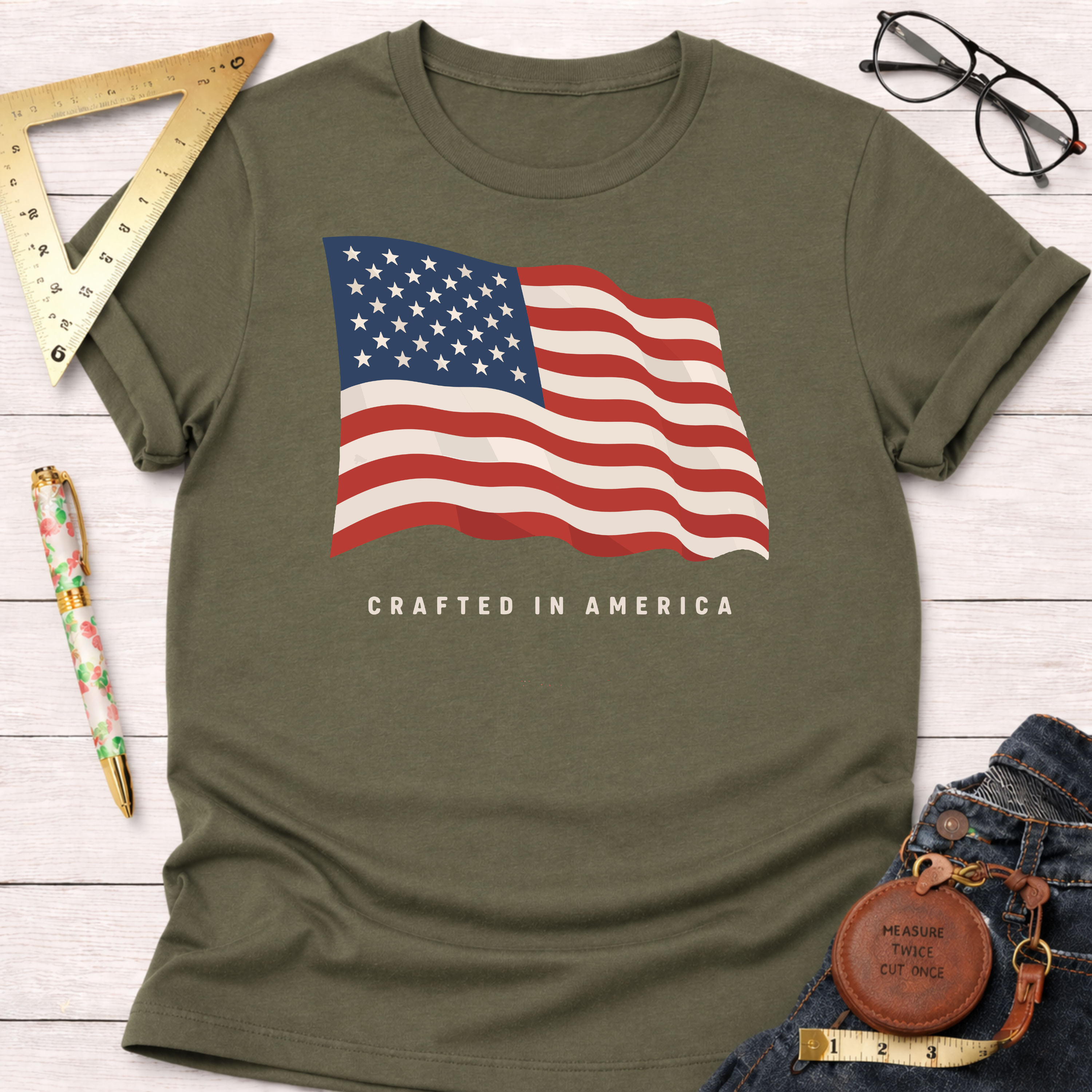 Olive green t-shirt with a waving American flag design and "CRAFTED IN AMERICA" text.