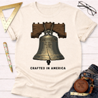 Cream t-shirt with a cracked Liberty Bell graphic and "CRAFTED IN AMERICA" text.