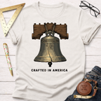 White cotton t-shirt with a detailed Liberty Bell graphic and "CRAFTED IN AMERICA" text.