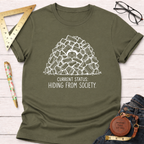 Olive green t-shirt with "Current Status: Hiding From Society" text and a person hiding in a woodpile graphic.