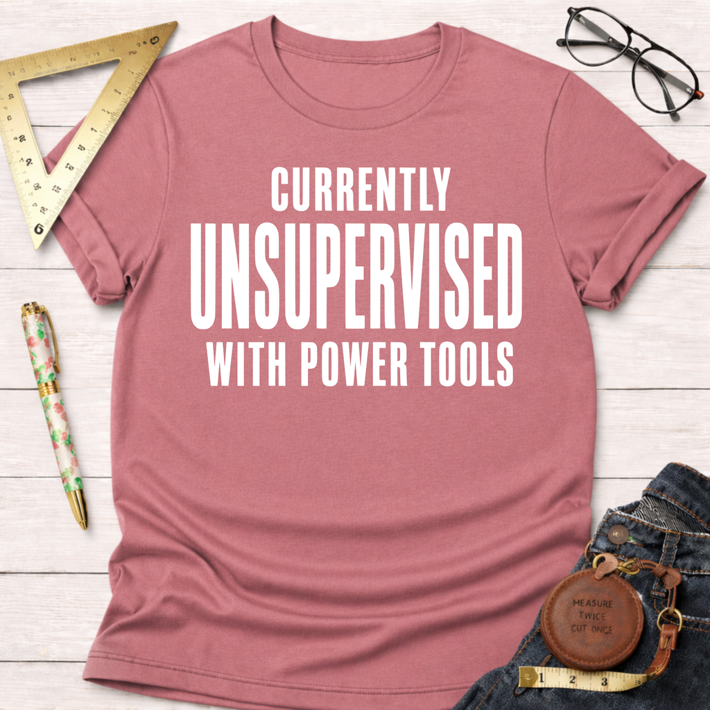 Women's funny woodworking graphic tee shirt for female woodworkers, makers, and DIY builders — Sawdust & Ponytails. Pink cotton t-shirt with "CURRENTLY UNSUPERVISED WITH POWER TOOLS" in white text.