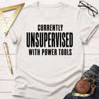 Women's funny woodworking graphic tee shirt for female woodworkers, makers, and DIY builders — Sawdust & Ponytails. Cream t-shirt with "CURRENTLY UNSUPERVISED WITH POWER TOOLS" in black text.