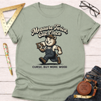 Women's funny woodworking graphic tee shirt for female woodworkers, makers, and DIY builders — Sawdust & Ponytails. Sage green cotton tee with a cartoon bear carrying wood and the text "Measure Twice, Cut Once. Curse. Buy More Wood.