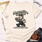 Women's funny woodworking graphic tee shirt for female woodworkers, makers, and DIY builders — Sawdust & Ponytails. Cream t-shirt with a bear carrying wood and saw, text "Measure Twice Cut Once Curse. Buy More Wood.