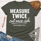Women's funny woodworking graphic tee shirt for female woodworkers, makers, and DIY builders — Sawdust & Ponytails. Dark olive green crewneck t-shirt with "MEASURE TWICE cut once-ish WE FIGURE IT OUT" in white text.