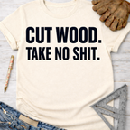 Women's funny woodworking graphic tee shirt for female woodworkers, makers, and DIY builders — Sawdust & Ponytails. Cream t-shirt with "CUT WOOD. TAKE NO SHIT." in black text.