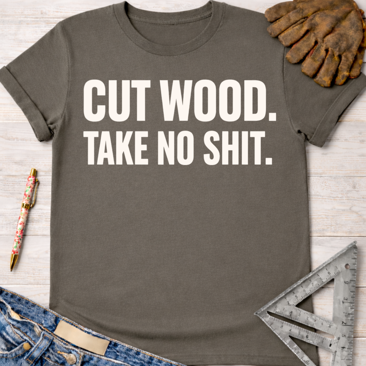 Charcoal gray women's "Cut Wood Take No Shit" graphic tee, with work gloves, jeans, and a ruler. Women's funny woodworking graphic tee shirt for female woodworkers, makers, and DIY builders — Sawdust & Ponytails
