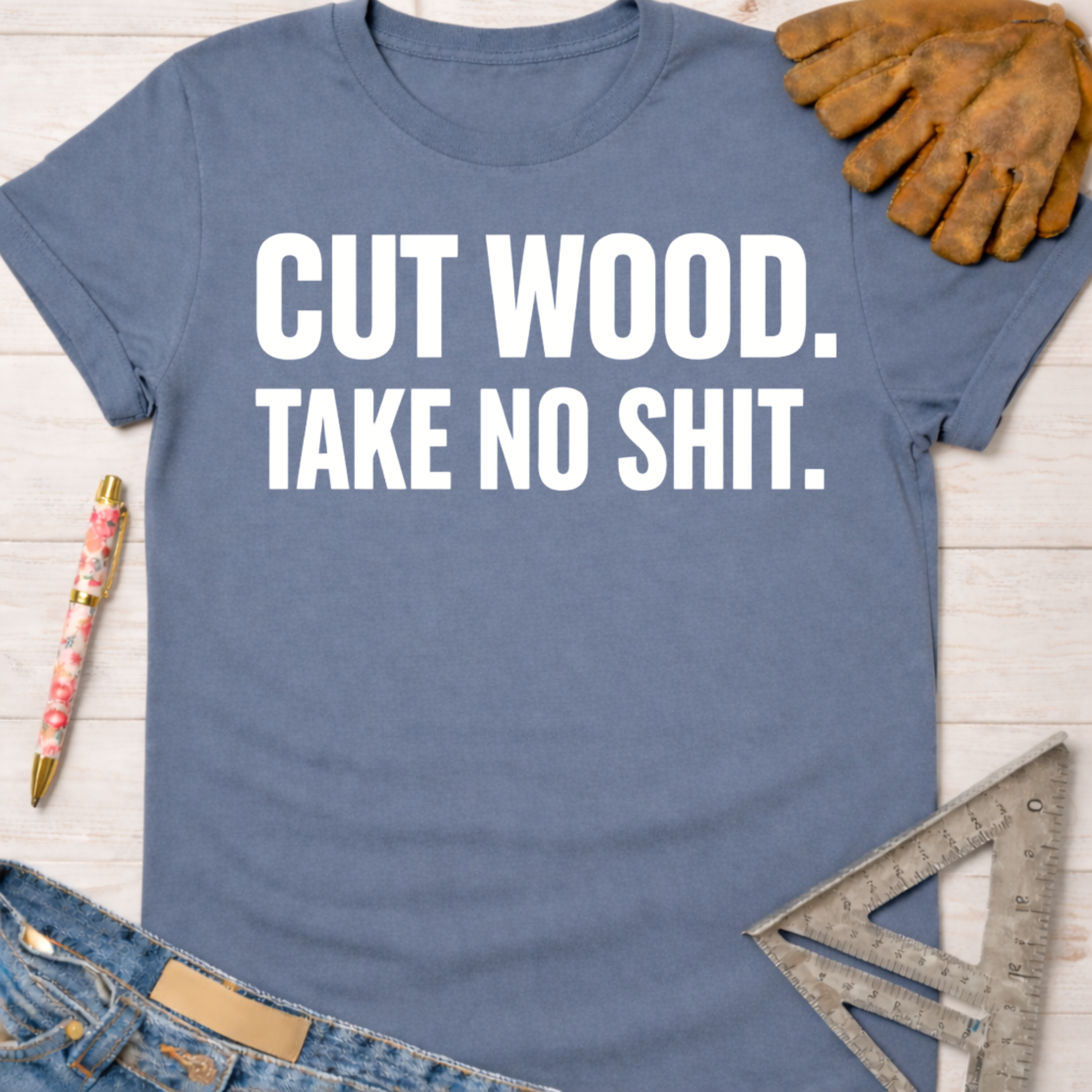 Women's funny woodworking graphic tee shirt for female woodworkers, makers, and DIY builders — Sawdust & Ponytails. Blue short-sleeve tee with "CUT WOOD. TAKE NO SHIT." in white text.