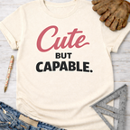 Women's funny woodworking graphic tee shirt for female woodworkers, makers, and DIY builders — Sawdust & Ponytails. Cream t-shirt with "Cute BUT CAPABLE." in pink and black.
