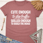 Women's funny woodworking graphic tee shirt for female woodworkers, makers, and DIY builders — Sawdust & Ponytails. Mauve t-shirt with "Cute Enough To Stop Traffic Skilled Enough To Build The Road" in white text.