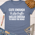Women's funny woodworking graphic tee shirt for female woodworkers, makers, and DIY builders — Sawdust & Ponytails. Blue cotton t-shirt with "Cute Enough To Stop Traffic Skilled Enough To Build The Road" in white text.