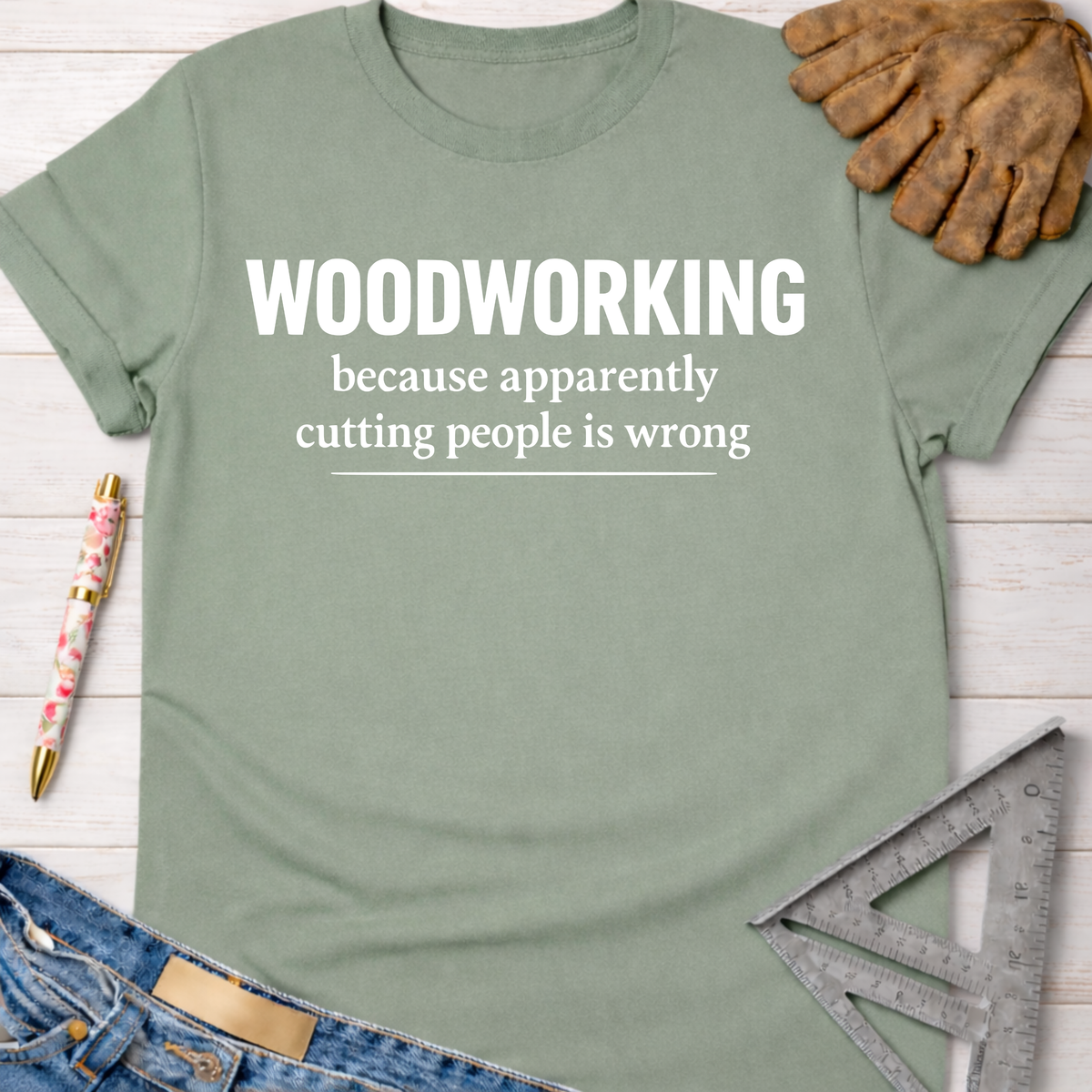 Women's funny woodworking graphic tee shirt for female woodworkers, makers, and DIY builders — Sawdust & Ponytails. Sage green cotton t-shirt with "WOODWORKING because apparently cutting people is wrong" text.