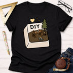 Women's funny woodworking graphic tee shirt for female woodworkers, makers, and DIY builders — Sawdust & Ponytails. Black cotton tee with a "DIY" computer button graphic featuring a workbench, saw, and circular saw.