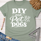 Women's funny woodworking graphic tee shirt for female woodworkers, makers, and DIY builders — Sawdust & Ponytails. Sage green cotton t-shirt with "DIY and Pet Dogs" text and a Schnauzer illustration.