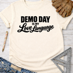 Women's funny woodworking graphic tee shirt for female woodworkers, makers, and DIY builders — Sawdust & Ponytails. Cream t-shirt with "Demo Day is My Love Language" in black text.