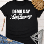 Black cotton Women's funny woodworking graphic tee shirt for female woodworkers, makers, and DIY builders — Sawdust & Ponytails, featuring "Demo Day is My Love Language" in white text.