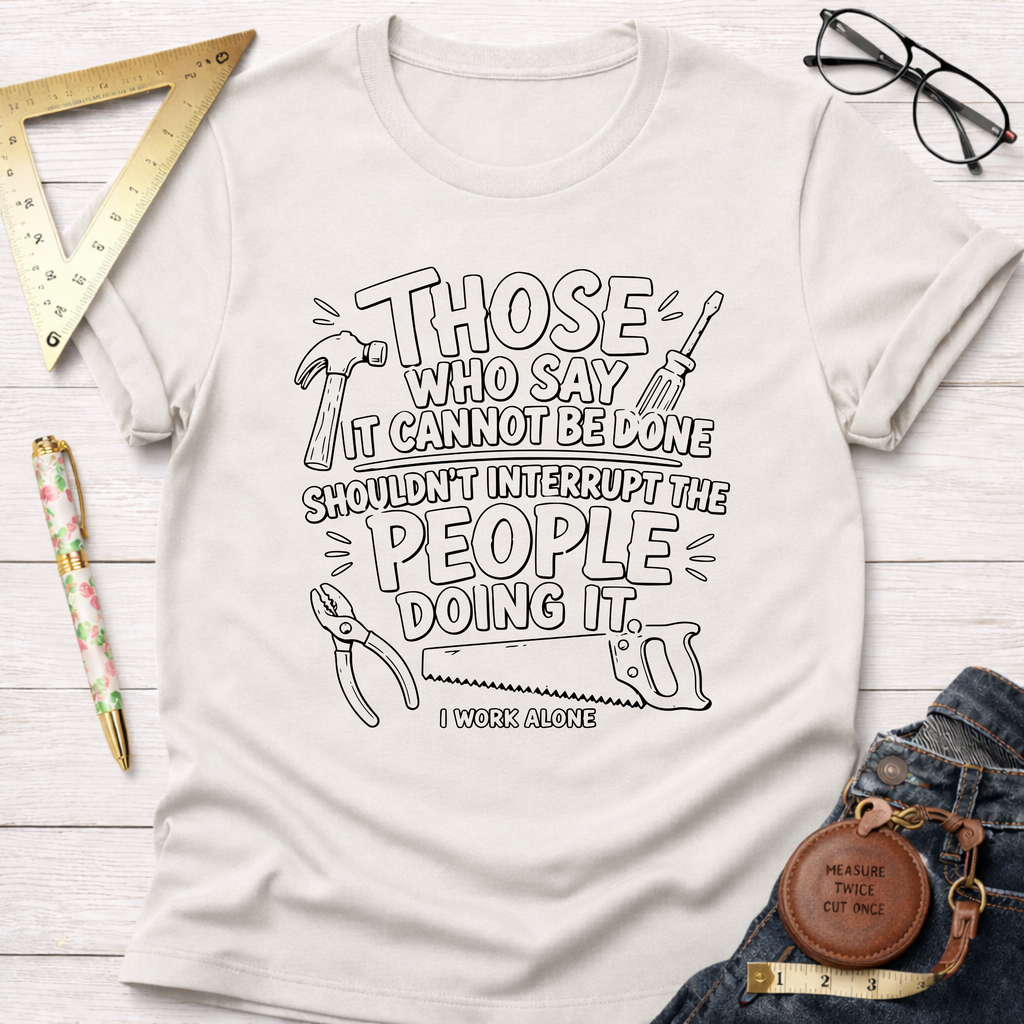 Cream t-shirt with "Those who say it cannot be done shouldn't interrupt the people doing it. I work alone" text and tools graphic.