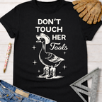 Black cotton t-shirt with a white graphic of a goose in a cowboy hat and boots, "Don't Touch Her Tools" text. Women's funny woodworking graphic tee shirt for female woodworkers, makers, and DIY builders — Sawdust & Ponytails