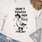 Women's funny woodworking graphic tee shirt for female woodworkers, makers, and DIY builders — Sawdust & Ponytails. White cotton tee with a goose in a cowboy hat and boots, "DON'T TOUCH HER Tools" text.