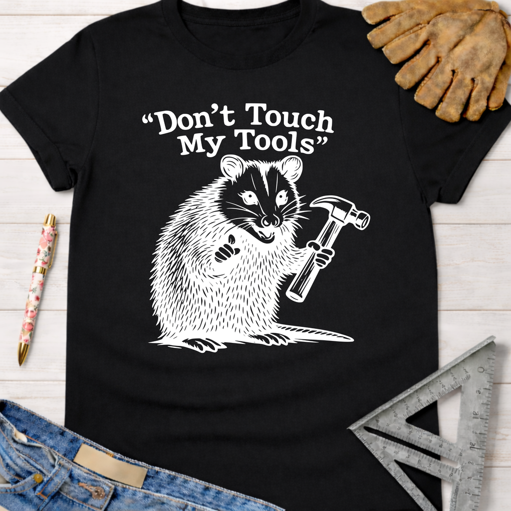Women's funny woodworking graphic tee shirt for female woodworkers, makers, and DIY builders — Sawdust & Ponytails. Black cotton tee with a white badger holding a hammer and "Don't Touch My Tools" text.
