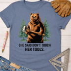 Women's funny woodworking graphic tee shirt for female woodworkers, makers, and DIY builders — Sawdust & Ponytails. Blue cotton t-shirt with a bear holding a mallet and "SHE SAID DON'T TOUCH HER TOOLS.