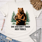 Women's funny woodworking graphic tee shirt for female woodworkers, makers, and DIY builders — Sawdust & Ponytails. White cotton tee with a brown bear holding a mallet and "SHE SAID DON'T TOUCH HER TOOLS." text.