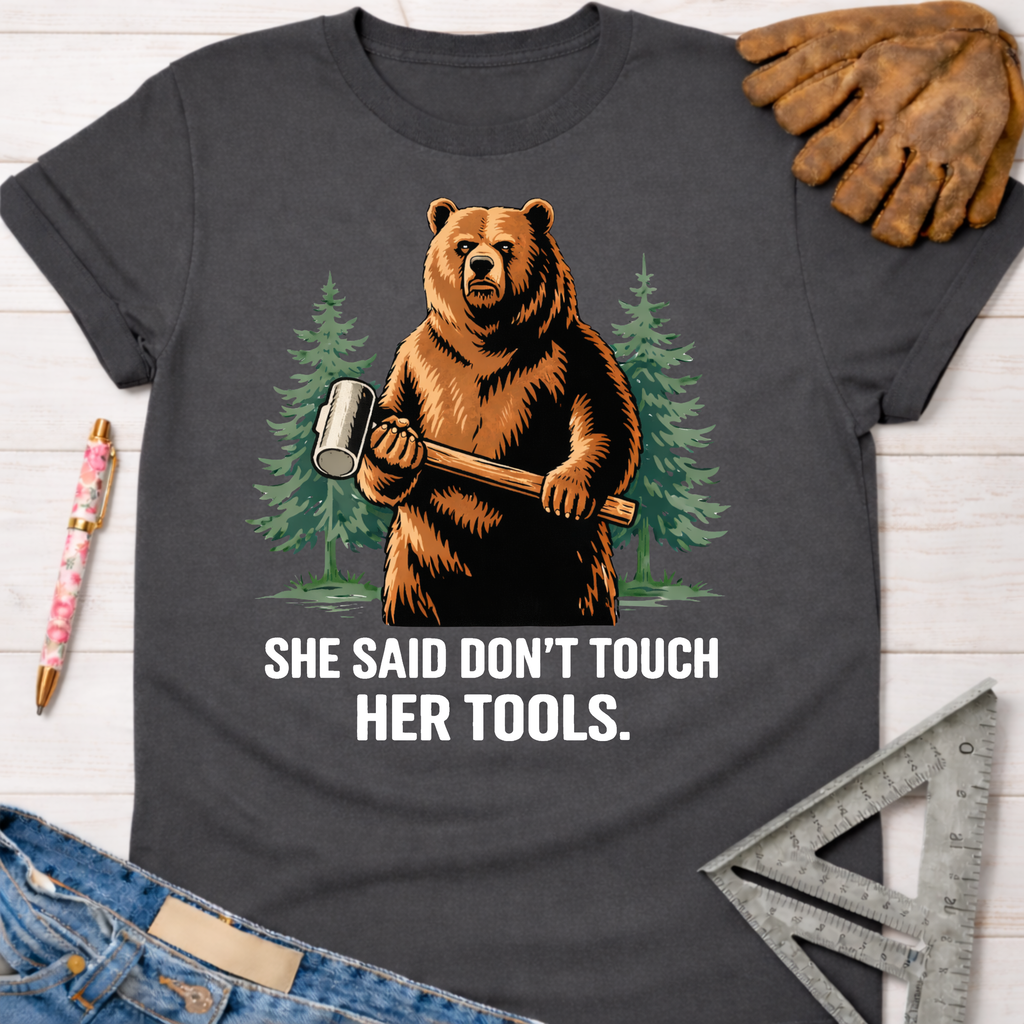 Charcoal gray cotton tee with a bear holding a mallet and "SHE SAID DON'T TOUCH HER TOOLS." graphic. Women's funny woodworking graphic tee shirt for female woodworkers, makers, and DIY builders — Sawdust & Ponytails