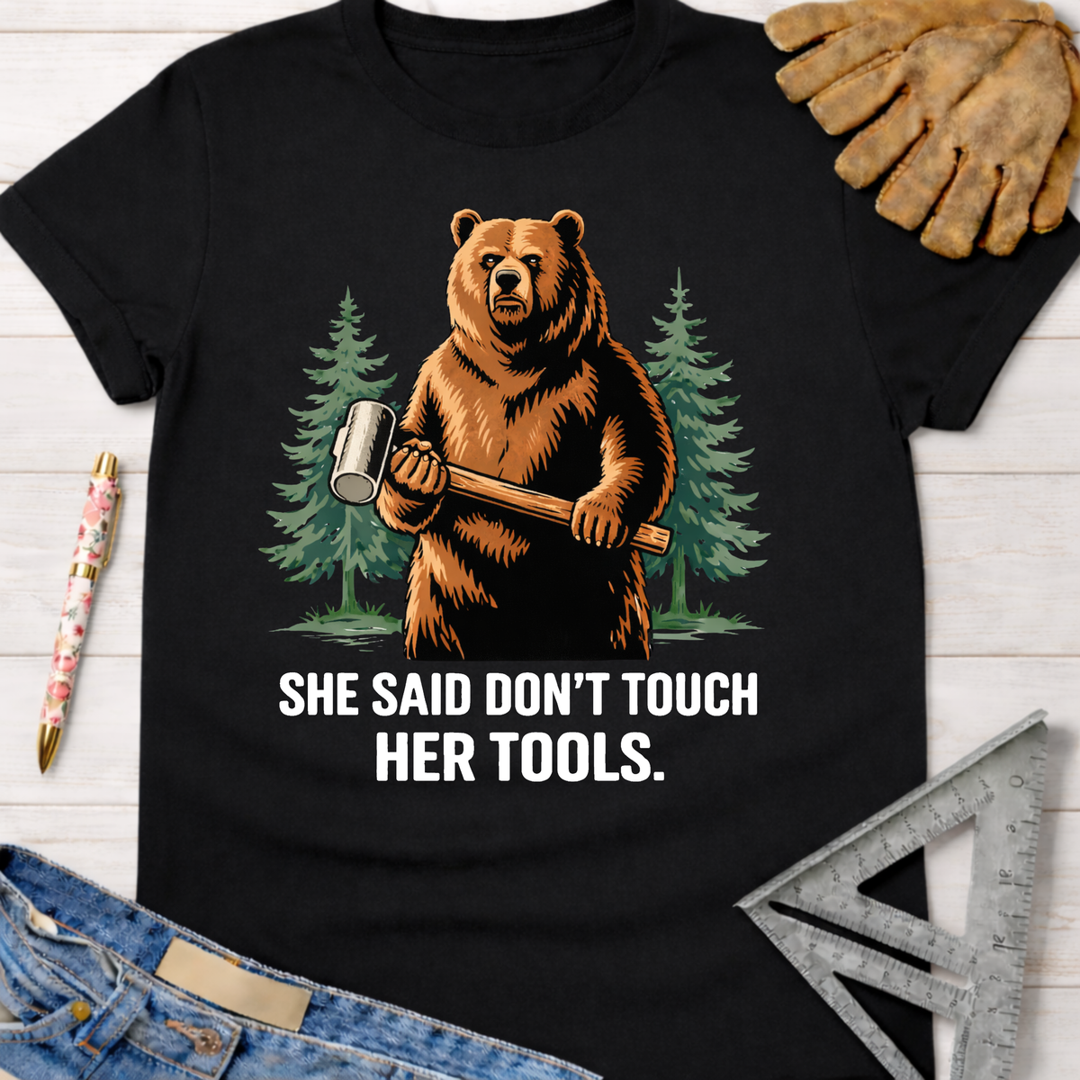 Black cotton t-shirt with a bear holding a mallet and "SHE SAID DON'T TOUCH HER TOOLS." graphic. Women's funny woodworking graphic tee shirt for female woodworkers, makers, and DIY builders — Sawdust & Ponytails