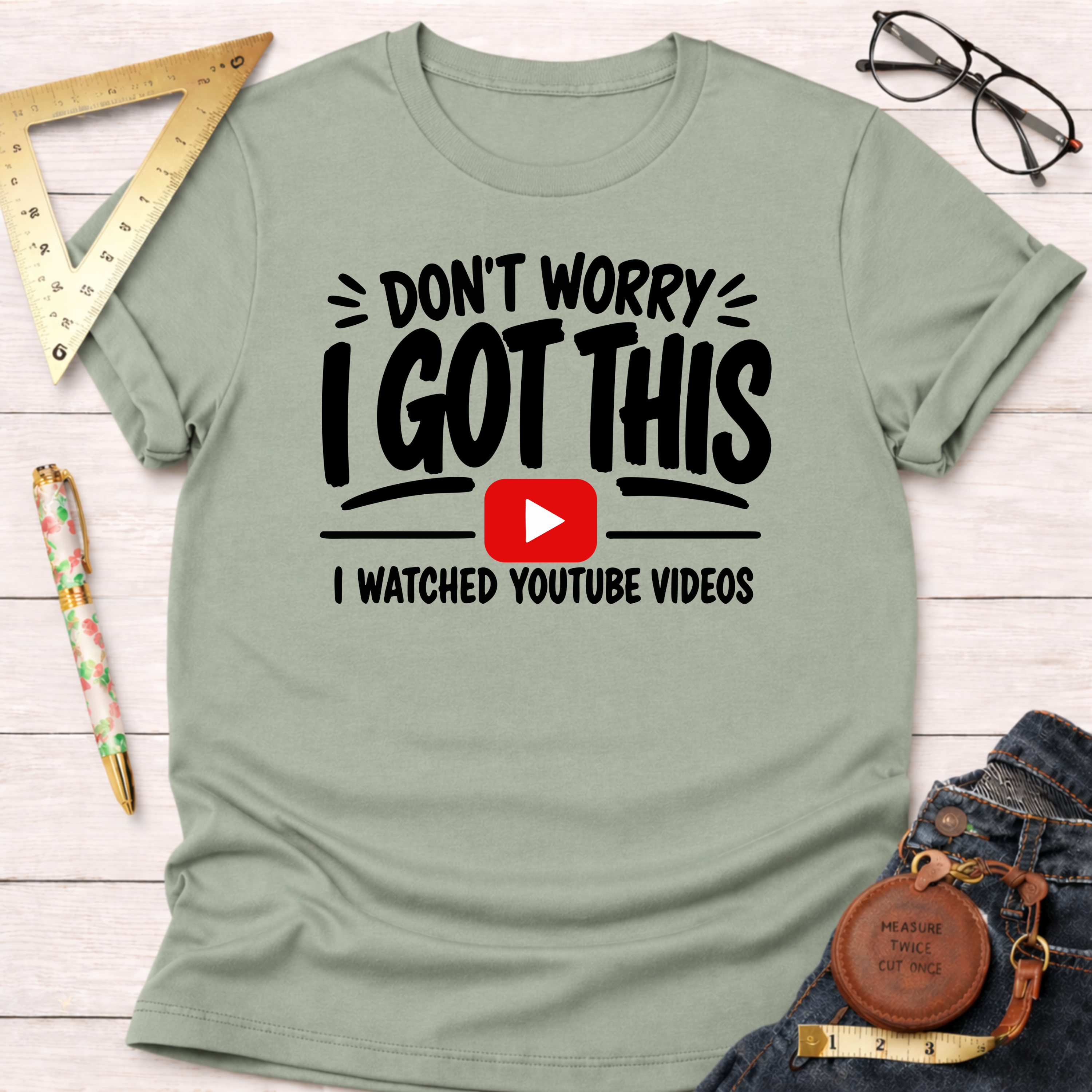 Sage green cotton t-shirt with "Don't Worry I Got This I Watched YouTube Videos" graphic.