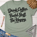 Women's funny woodworking graphic tee shirt for female woodworkers, makers, and DIY builders — Sawdust & Ponytails. Sage green cotton tee with "Drink Coffee. Build Stuff. Be Happy." in black script.