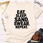 Cream cotton t-shirt with "Eat. Sleep. Sand. Swear. Repeat." in bold black text.