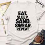 Cream t-shirt with "EAT. SLEEP. SAND. SWEAR. REPEAT." in bold black text.