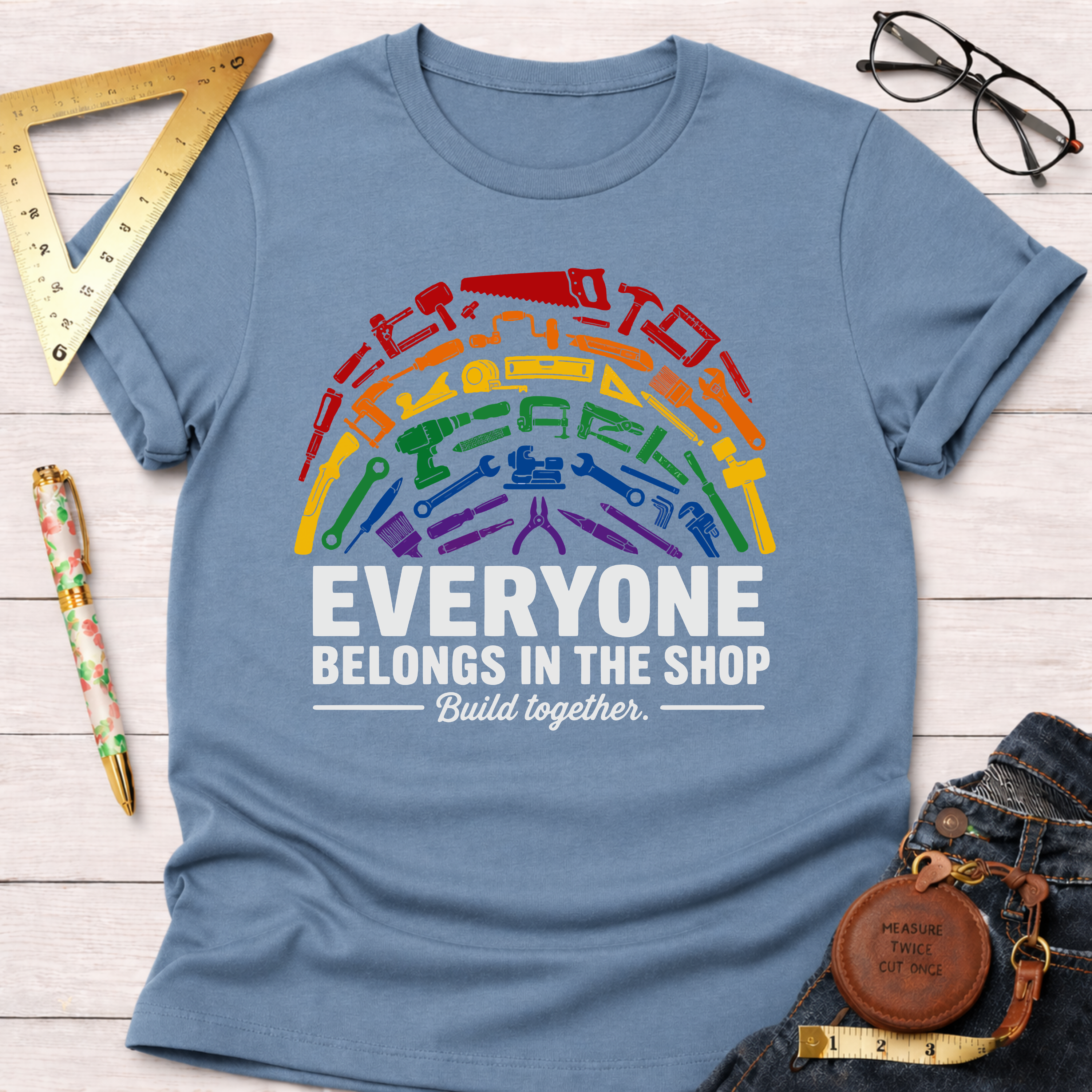 Light blue unisex cotton t-shirt with a rainbow of colorful tools and "Everyone Belongs In The Shop Build together." text.