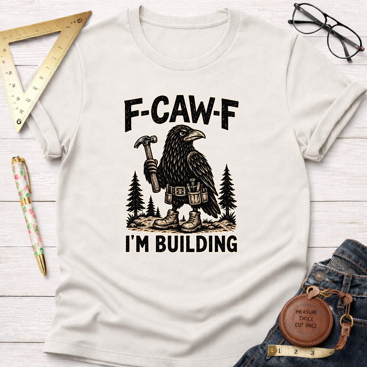 White cotton F-CAW-F, I'm Building T-shirt with a black crow carpenter graphic.