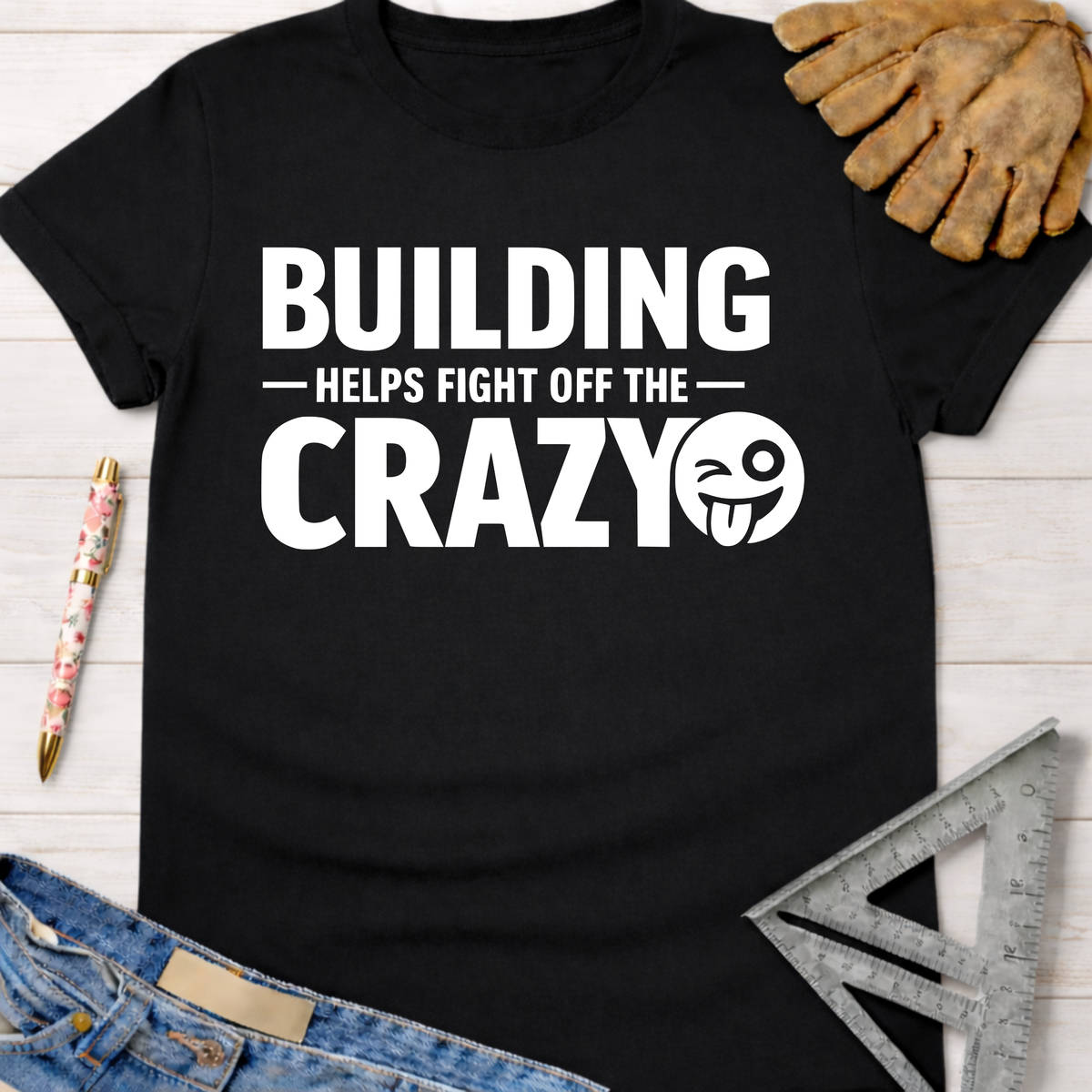 Women's funny woodworking graphic tee shirt for female woodworkers, makers, and DIY builders — Sawdust & Ponytails. Black cotton tee with "BUILDING HELPS FIGHT OFF THE CRAZY" text and winking emoji.