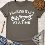 Charcoal gray "Figuring It Out One Project At A Time" women's funny woodworking graphic tee shirt for female woodworkers, makers, and DIY builders — Sawdust & Ponytails