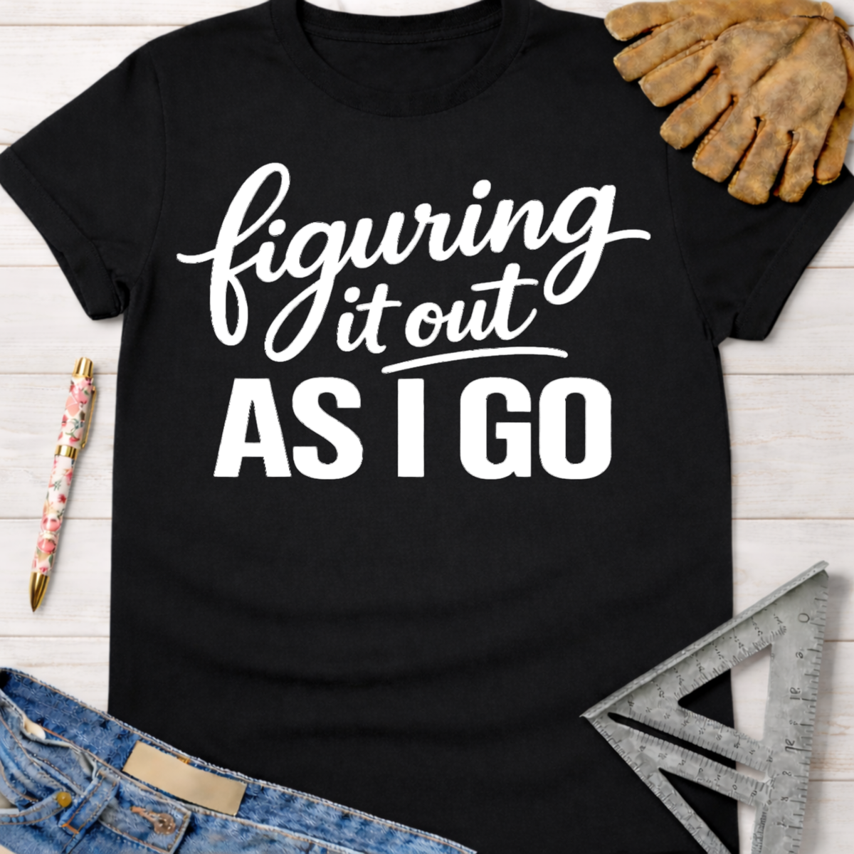 Black cotton t-shirt with "Figuring It Out As I Go" in white text. Women's funny woodworking graphic tee shirt for female woodworkers, makers, and DIY builders — Sawdust & Ponytails