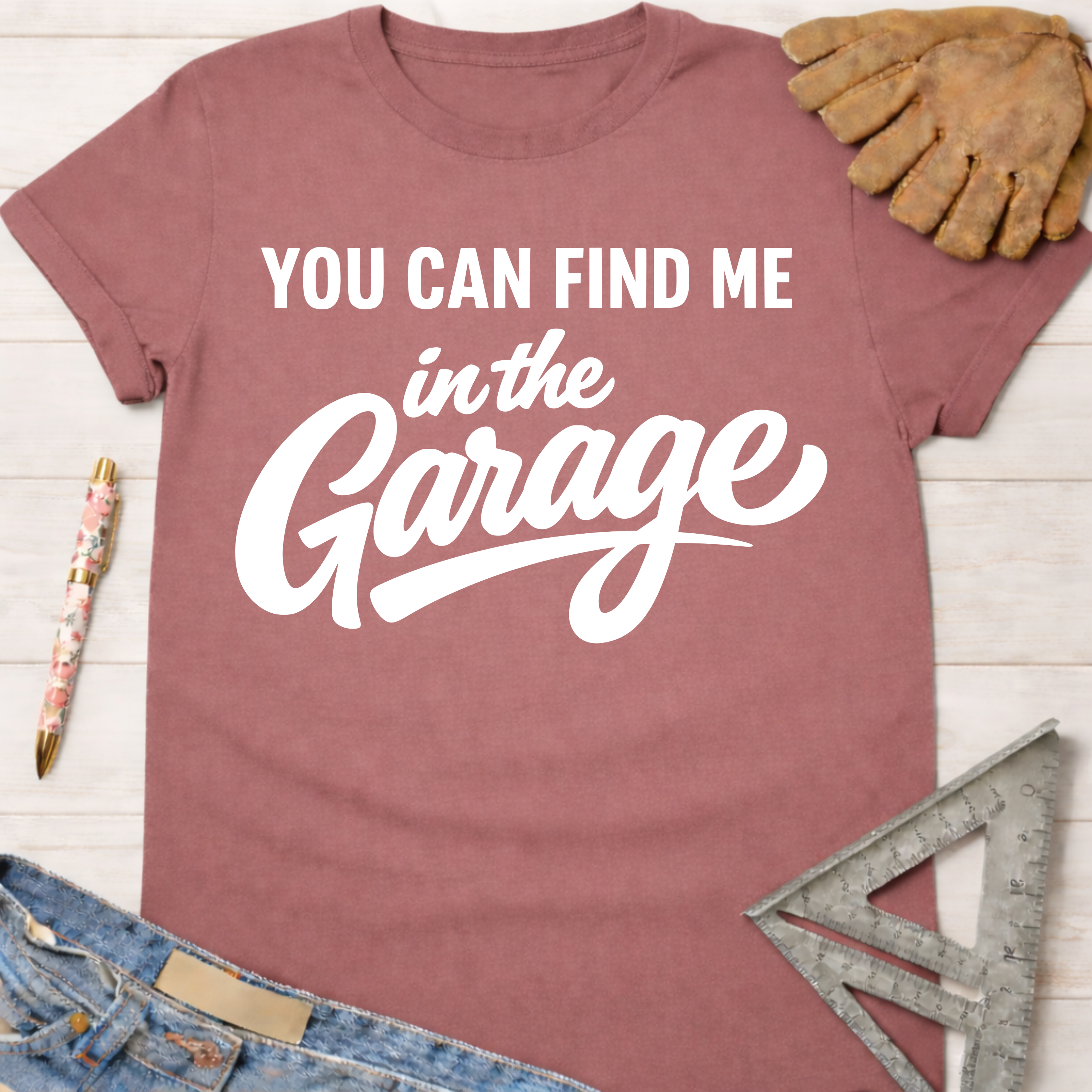 Women's funny woodworking graphic tee shirt for female woodworkers, makers, and DIY builders — Sawdust & Ponytails. Mauve pink short-sleeve t-shirt with "YOU CAN FIND ME in the Garage" in white text.