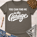Women's funny woodworking graphic tee shirt for female woodworkers, makers, and DIY builders — Sawdust & Ponytails. Charcoal gray cotton tee with "YOU CAN FIND ME in the Garage" in white script.