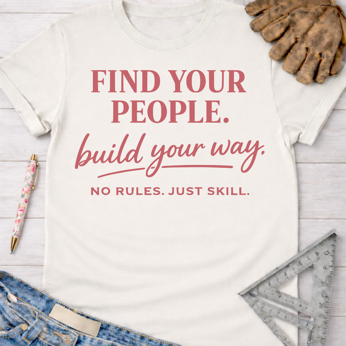 Women's funny woodworking graphic tee shirt for female woodworkers, makers, and DIY builders — Sawdust & Ponytails. Light cream cotton tee with "Find Your People. build your way. NO RULES. JUST SKILL." in red text.