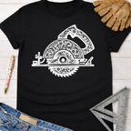 Black women's tee with white floral engraved circular saw graphic, jeans, and work glove.