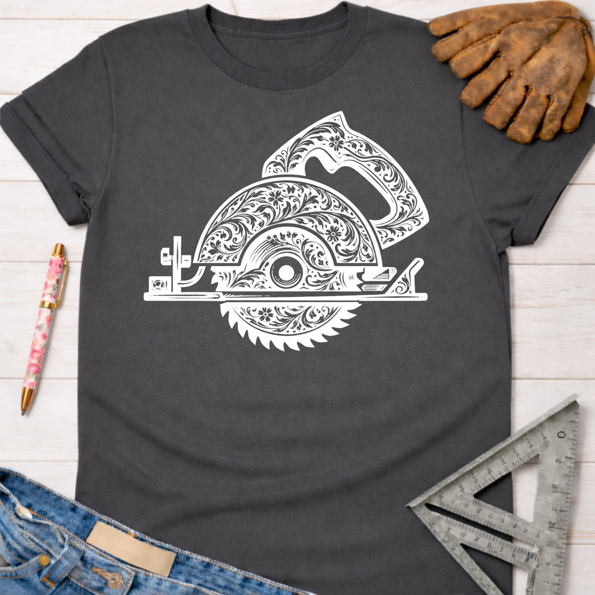 Charcoal gray women's tee with white floral engraved circular saw graphic. Women's funny woodworking graphic tee shirt for female woodworkers, makers, and DIY builders — Sawdust & Ponytails.