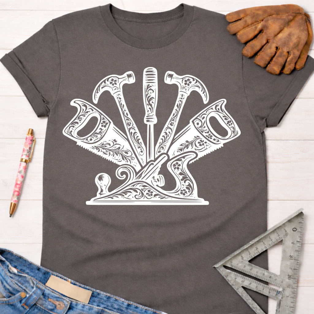 Women's funny woodworking graphic tee shirt for female woodworkers, makers, and DIY builders — Sawdust & Ponytails. Dark gray t-shirt with a white floral-detailed hammer, saw, and screwdriver graphic.