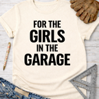 Women's funny woodworking graphic tee shirt for female woodworkers, makers, and DIY builders — Sawdust & Ponytails. Cream t-shirt with "FOR THE GIRLS IN THE GARAGE" in black text.
