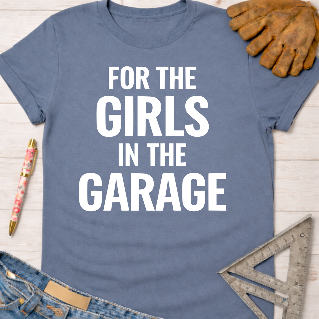 Women's funny woodworking graphic tee shirt for female woodworkers, makers, and DIY builders — Sawdust & Ponytails. Blue cotton t-shirt with "FOR THE GIRLS IN THE GARAGE" in white text.