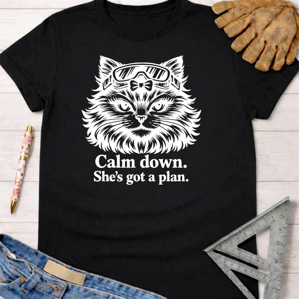 Black cotton tee with white graphic of a cat in safety goggles and "Calm down. She's got a plan." Women's funny woodworking graphic tee shirt for female woodworkers, makers, and DIY builders — Sawdust & Ponytails