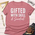 Heather dusty rose t-shirt with "Gifted With Skill & Sawdust" in white text, styled with jeans.